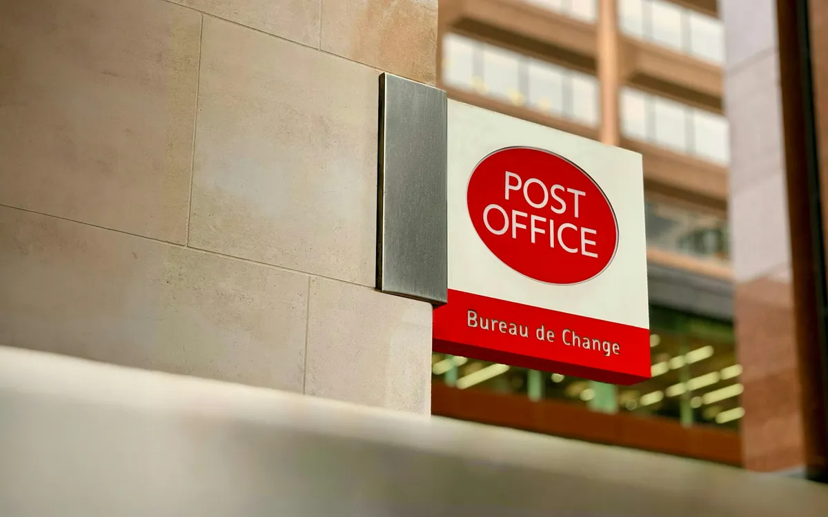 A Post Office branch sign on a high-street building
